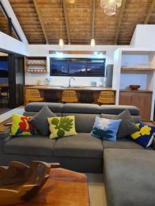 TemaeMoorea Lodge Bungalow的客厅配有带色彩缤纷枕头的灰色沙发