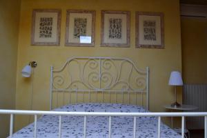 克雷马托拉佐Il住宿加早餐旅馆的卧室设有白色的床铺和黄色的墙壁