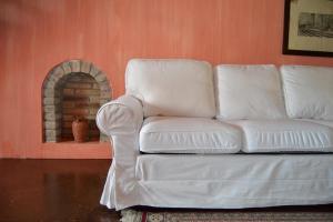 克雷马托拉佐Il住宿加早餐旅馆的客厅设有1张白色沙发,配有壁炉
