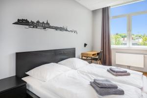 弗赖塔尔Hostel Am Windberg的卧室配有白色的床和2条毛巾