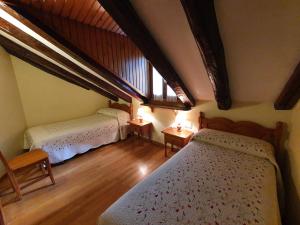 托尔拉Casa Duplex La Buhardilla的一间卧室设有两张床和大窗户