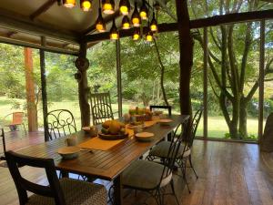 蒙泰韦尔德哥斯达黎加YerbaBuena Modern Stay in the Cloud Forest的一间带木桌和椅子的用餐室
