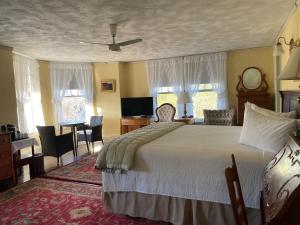 巴港Moseley Cottage Inn and The Town Motel的卧室配有一张床和一张桌子及椅子
