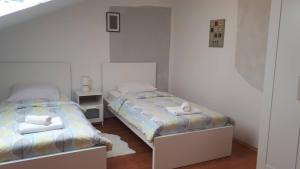TenjaGuest house Ruža的白色客房内的两张床,配有两张sidx sidx sidx床