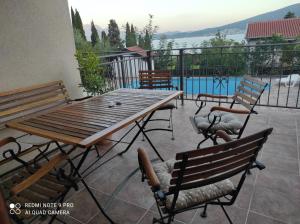 鲍希茨Mio Lux的一个带木桌和椅子的庭院和一个游泳池