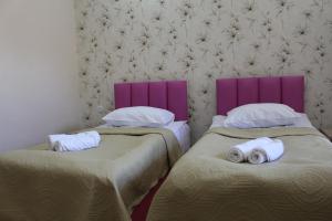 阿哈尔齐赫Hotel Rabati的紫色床头板客房内的两张床