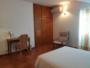 Sorbo-OcagnanoDomaine de Valle的卧室配有一张床、一张桌子和椅子