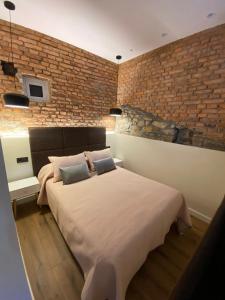 阿维莱斯Apartamentos Rosa La Bonita的一间卧室设有一张大床和砖墙