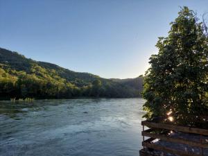 LjubovijaKutak na Drini的享有河流美景,设有围栏和树木