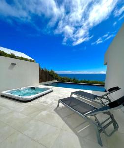 拉戈阿Sul Villas & Spa - Azores的一个带椅子的庭院和一个游泳池