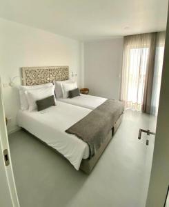 拉戈阿Sul Villas & Spa - Azores的一间白色的大卧室,配有一张带枕头的大床