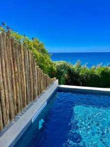 拉戈阿Sul Villas & Spa - Azores的毗邻木栅栏和大海的游泳池