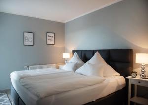 费曼城堡Strandhaus "Düne 55"的一间卧室配有一张带两盏灯的大型白色床。