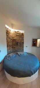 卡斯泰尔梅扎诺Il Gelsomino的一间卧室设有一张带石墙的大床