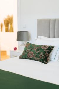 阿利若Casa d'Arcã的一张白色的床,上面有绿色枕头