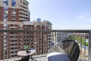 阿林顿Exquisite 1 Bedroom Condo At Ballston With Gym的阳台配有两把椅子和一张桌子,部分建筑