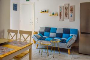 斯基亚索斯镇Albertoshouse的客厅配有蓝色的沙发和桌子
