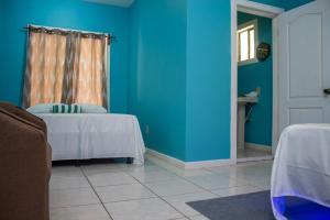西区Bliss on the Bay family的一间设有两张床和蓝色墙壁的客房