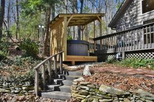 阿什维尔The Camby Cabin just 12 miles to downtown Asheville的门廊,设有木制凉亭和楼梯,毗邻房子