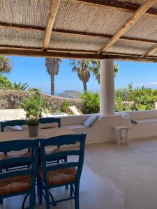 菲利库迪岛Le Sette Sorelle的一个带桌椅和棕榈树的庭院