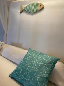 菲利库迪岛Le Sette Sorelle的床上有枕头,墙上有鱼
