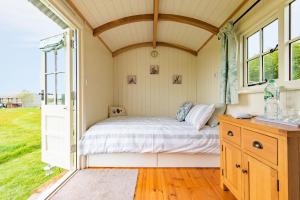 埃杰顿Take Time Shepherd's Huts by Bloom Stays的一个小房间的一个床位,设有窗户