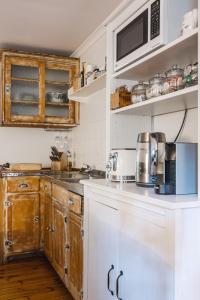 Aldgate阿尔德盖特谷住宿加早餐旅馆的一间带木制橱柜和微波炉的厨房