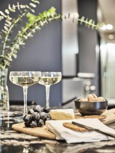 墨尔本Melbourne City Apartment Hotel的一张桌子,上面放着两杯葡萄酒和葡萄