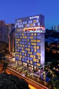 新加坡Quincy Hotel Singapore by Far East Hospitality的夜间与城市的建筑 ⁇ 染