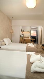 米尔泰Horizon Hotel Kalymnos的酒店客房设有两张床和一张桌子。