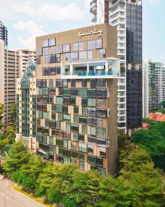 新加坡Quincy Hotel Singapore by Far East Hospitality的一座高大的建筑,城市里有很多窗户