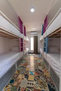 巴利亚多利德New friends hostel & Bar Adults Only的客房设有两张双层床,铺有瓷砖地板。