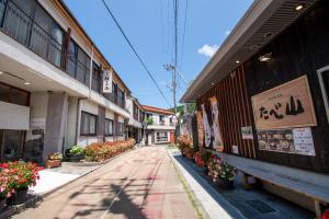 长门Guesthouse Neruyama的一条空的街道,在建筑物的一侧有鲜花