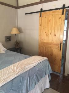 坎顿Acorn Hideaways Canton Sweet Tweet Guesthouse King Bed的一间卧室配有一张床和一扇木门