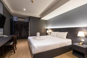曼谷暹罗之星酒店的酒店客房配有一张床、一张书桌和一张四柱床