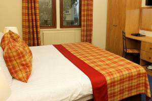 格拉斯哥吹笛者幽会酒店的一间卧室配有一张带铺着平底毯的床