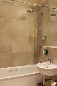 格拉斯哥吹笛者幽会酒店的一间带水槽、浴缸和淋浴的浴室