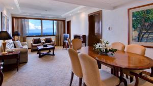 宿务Marco Polo Plaza Cebu的一间带餐桌的客厅和一间客厅。