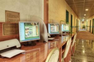 圣地亚哥迪亚戈阿马格阿罗普多酒店的坐在一张桌子上的一排电脑显示器