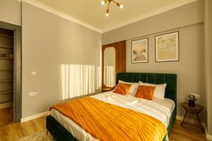 马马亚Lago Apartment Mamaia Butoaie的一间卧室配有一张带橙色和白色床单的大床