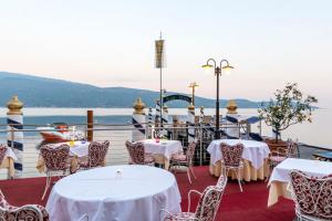 加尔尼亚诺Hotel Baia D'Oro - Adults Only的船上的餐厅,配有桌椅