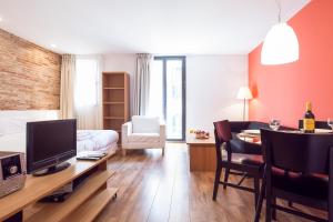 巴塞罗那巴塞罗那市内桑兹公寓的客厅配有一张床和一张书桌及电视