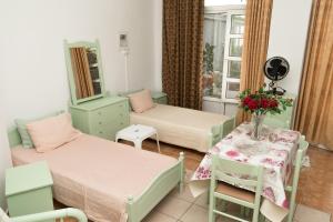 科斯镇STAVROS Studio Apartment in kos town的一间设有两张床的房间和一张鲜花桌子