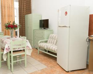 科斯镇STAVROS Studio Apartment in kos town的厨房配有白色冰箱和桌椅