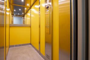 利特威诺夫Apartmány a Studia Zámecký park的一条走廊,有黄色的墙壁和黄色的电梯