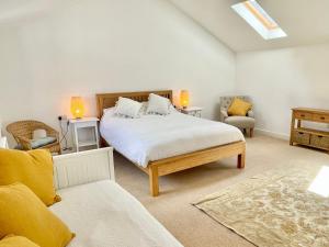 赫尔姆斯利Rye Court Cottage - Stunning cottage in central Helmsley with parking的一间卧室配有一张大床和两把椅子