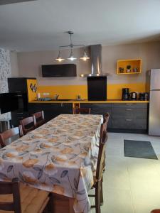 ChâteauvieuxPassion的一间带桌子的厨房和一间带黄色墙壁的厨房