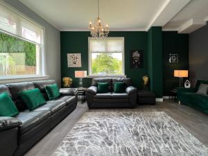 巴洛赫Loch Lomond Mews的客厅设有绿色的墙壁和沙发