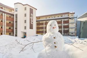 瑟伦贝格Reka-Feriendorf Sörenberg的建筑物前的雪人