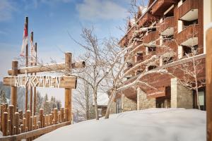 瑟伦贝格Reka-Feriendorf Sörenberg的建筑物旁边的雪地里的一个街道标志